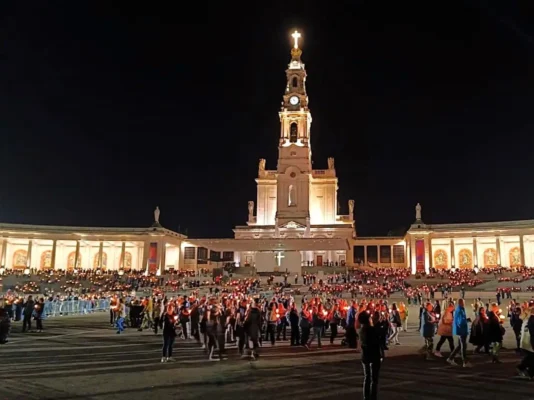 Fatima, pellegrini che iniziano la processione serale con le fiaccole, In sfondo basilica santo Rosario del santuario. Pellegrinaggio Tu Sei Pietro Viaggi